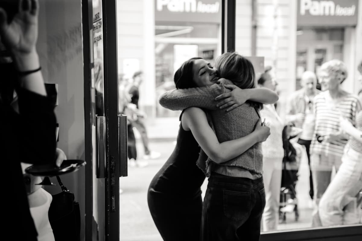 Due ragazze che si abbracciano sulla soglia di una porta